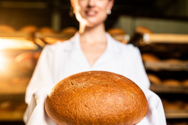 Pane. Linea di produzione del pane. pane nella mano della donna.