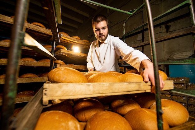 Pane. Linea di produzione del pane. Un uomo in uniforme. Controllo sanitario.