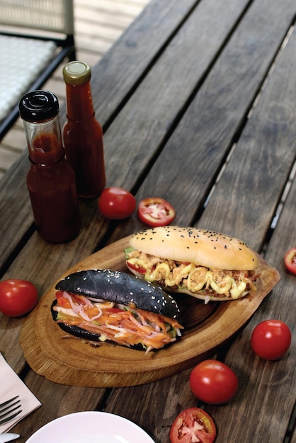 Pane marrone e nero tradizionale dell'hamburger sul piatto di legno