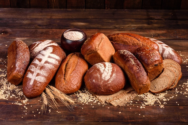 Pane nero al forno fresco su una tavola di legno marrone. Pane tradizionale appena sfornato