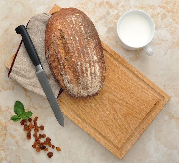 Pane nero su superficie di legno con latte e uvetta