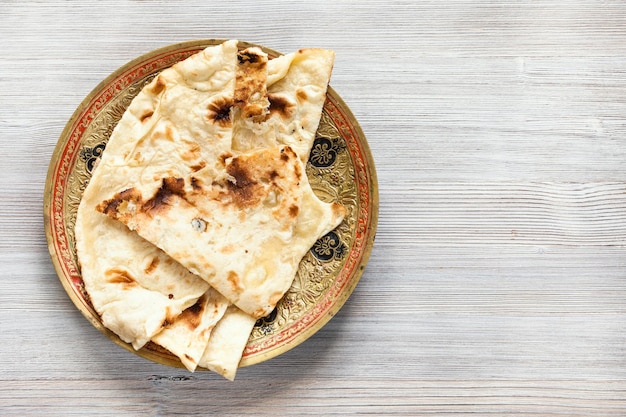 Pane piatto Naan sul piatto sulla tavola di legno