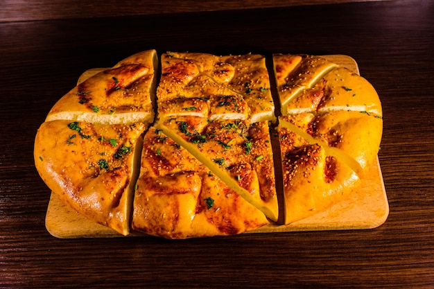 Pane pita affettato con aglio su un tagliere di legno