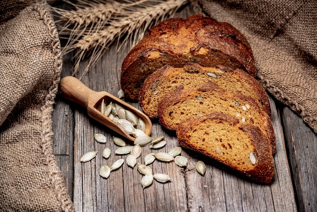 Pane rustico con zucca e semi di zucca su un vecchio tavolo in legno.