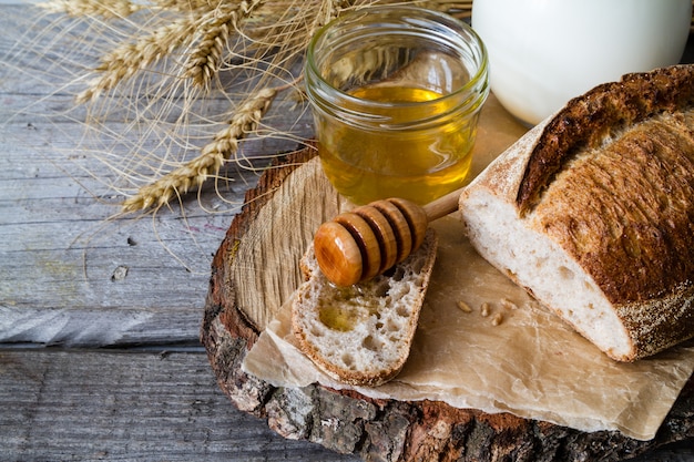 Pane, segale, frumento, miele, fondo rustico di legno del latte