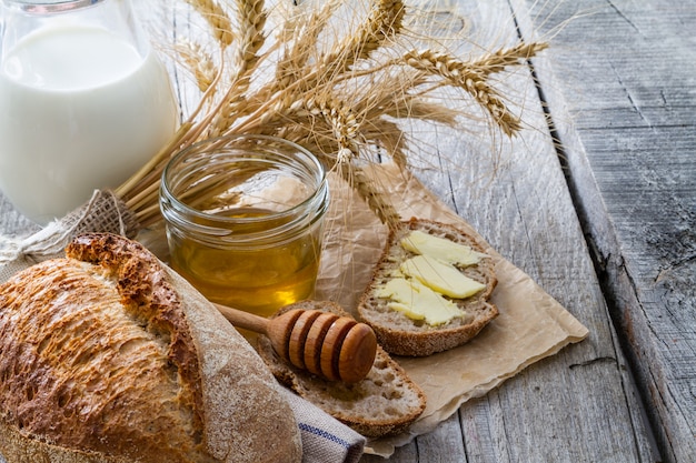 Pane, segale, frumento, miele, fondo rustico di legno del latte