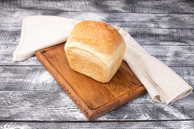 Pane su un piatto di legno bianco del fondo di legno