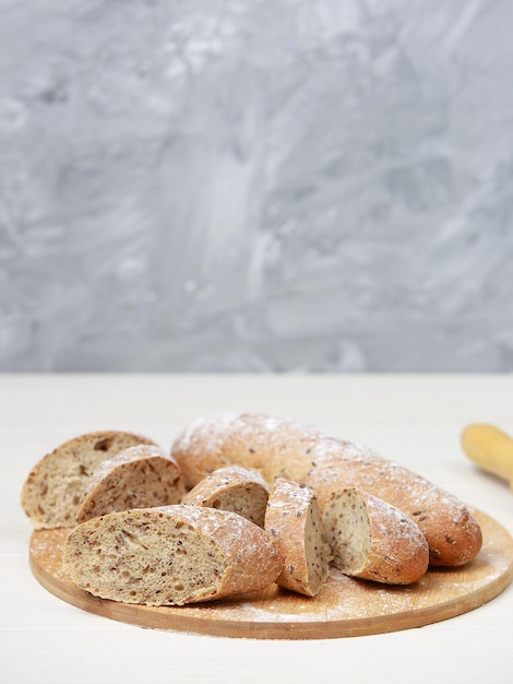 Pane su un tagliere. Pane di segale integrale. Sul tavolo di legno chiaro