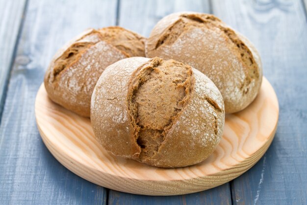 Pane sul piatto di legno sulla tavola blu