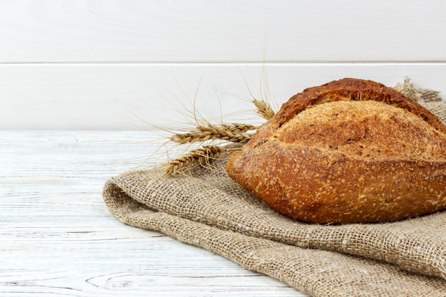 Pane sul tavolo. Cottura di pasta su un fondo di legno bianco