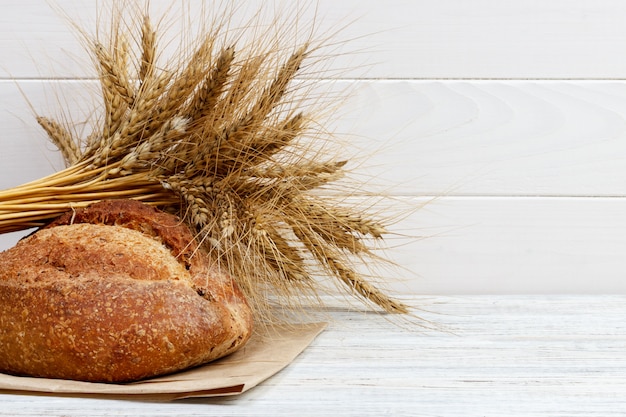 Pane sul tavolo, pane fatto in casa con grano su un fondo di legno