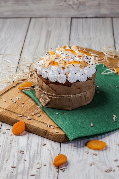 Pane torta pasquale decorato con caramelle albicocche secche e semi di girasole su sfondo di legno Concetto di vacanze