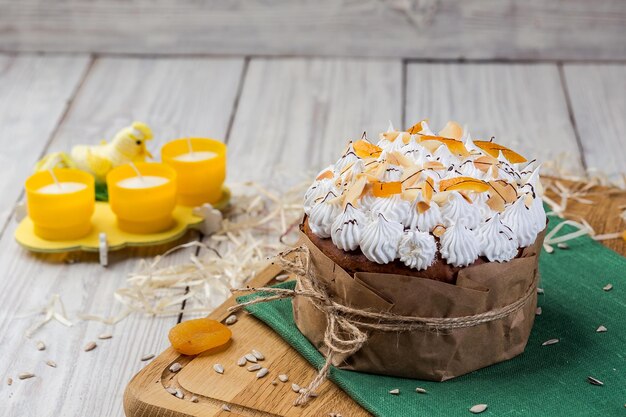 Pane torta pasquale decorato con caramelle albicocche secche e semi di girasole su sfondo di legno Concetto di vacanze