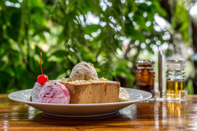 Pane tostato al miele con gelato e frutta condita con sciroppo di cioccolato e miele