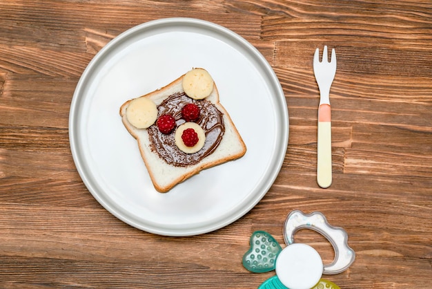 Pane tostato con burro di arachidi, formaggio e lampone su fondo di legno piatto. Bambini bambino dolce dessert colazione pranzo cibo.