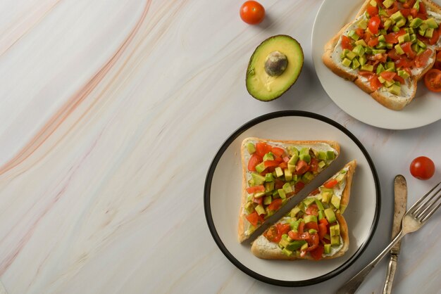 Pane tostato con crema di formaggio, avocado e pomodorini. Cibo salutare. Copia spazio