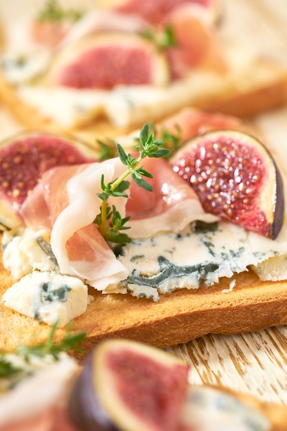 Pane tostato con fichi dolci, formaggio blu e close-up prosciutto affumicato