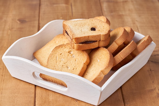 Pane tostato con marmellata di prugne sullo sfondo bianco.