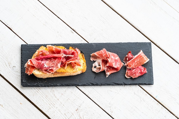 Pane tostato con olio d'oliva e prosciutto iberico alimentato con ghiande al mattino prima della colazione