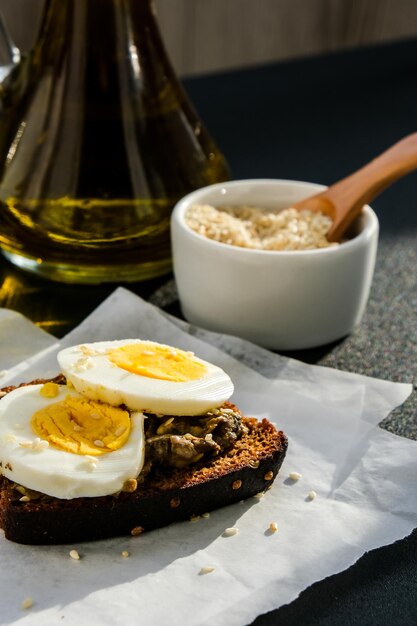 Pane tostato con uova sode e avocado. Panini al guacamole. Colazione salutare. Olio d'oliva. Semi di sesamo. Alimentazione sana vegetariana.