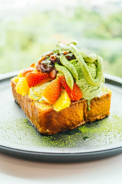 Pane tostato dolce al dessert con gelato matcha e fragola, arancio