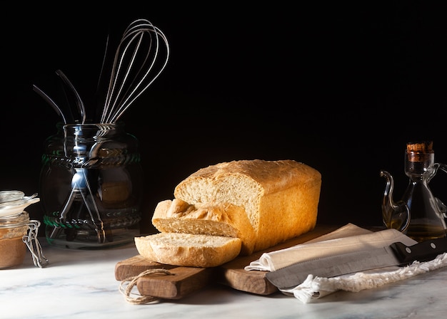 Pane tostato fresco fatto in casa sul tavolo della cucina, sfondo scuro.