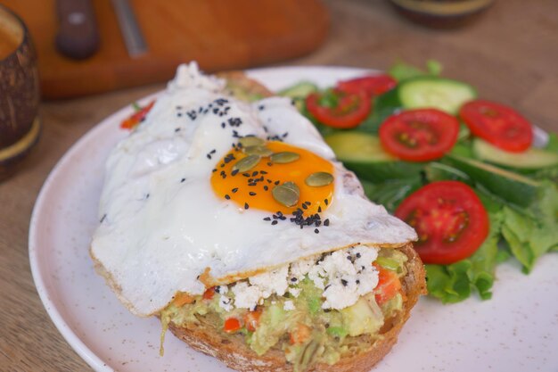 Pane tostato fresco saporito con l'avocado e l'uovo