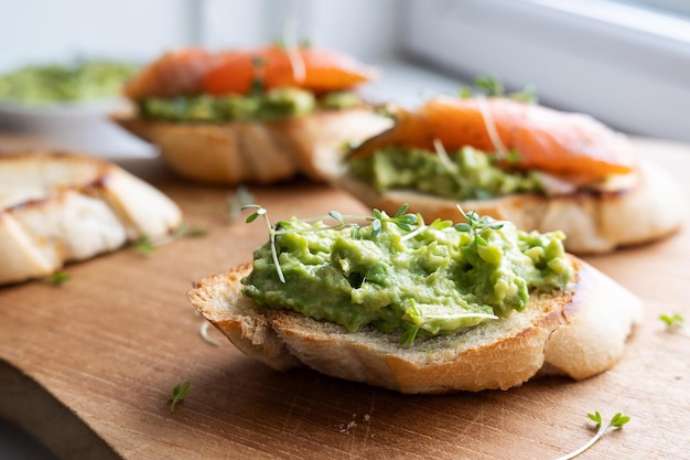 Pane tostato sano con guacamole e fettine di salmone ciotola con avocado