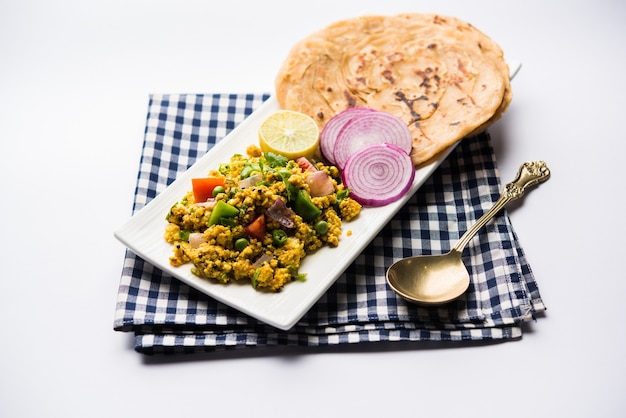 Paneer Bhurji, ricotta leggermente speziata strapazzata e servita con roti o laccha paratha, messa a fuoco selettiva