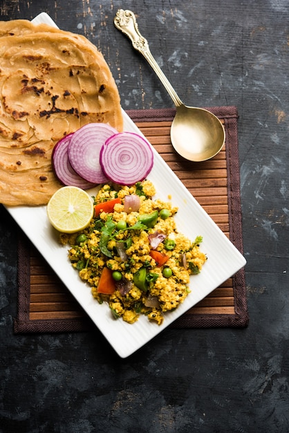 Paneer Bhurji, ricotta leggermente speziata strapazzata e servita con roti o laccha paratha, messa a fuoco selettiva