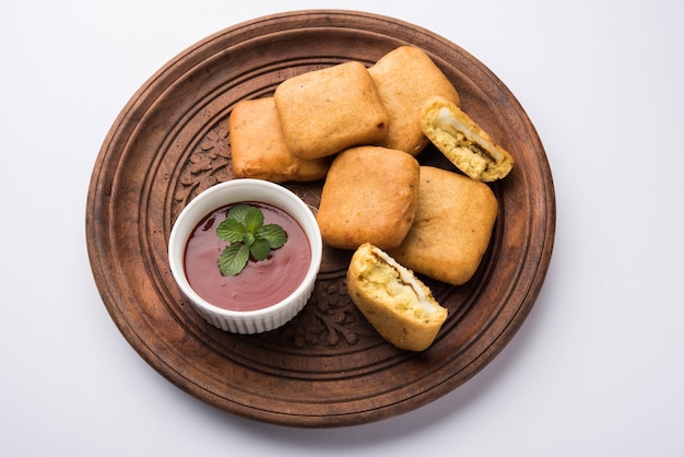 Paneer pakoras o Bhajji sono cubetti di ricotta piccanti ricoperti di farina di ceci o pastella di besan. Servito con ketchup di pomodoro in un piatto su sfondo colorato o in legno. Messa a fuoco selettiva