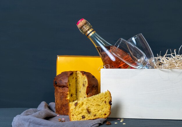 Panetone di Pasqua italiano con bottiglia di champagne e due bicchieri su sfondo blu.