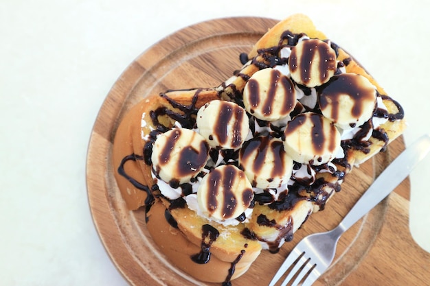 Panetteria casalinga di cioccolato bianco tostato e banana su piastra di legno vista dall'alto
