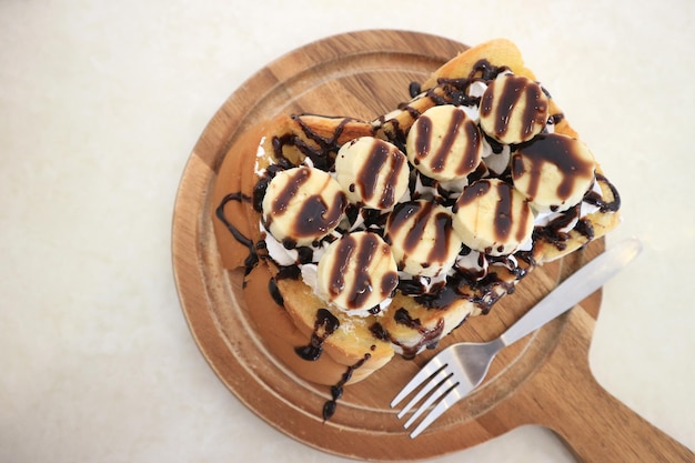 Panetteria casalinga di cioccolato bianco tostato e banana su piastra di legno vista dall'alto