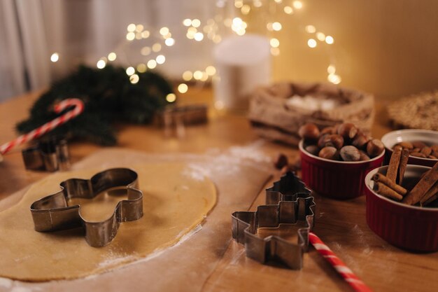 Panetteria domestica che cucina dolci festivi tradizionali che tagliano biscotti di pasta di pan di zenzero cruda su legno