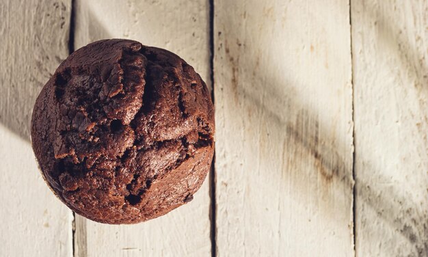 Panetteria fatta in casa di muffin al cioccolato su un tavolo di legno con spazio per la copia