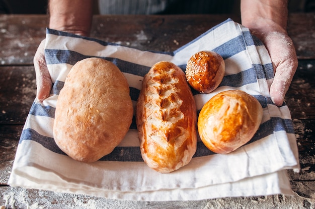 Panettiere che tiene il primo piano del pane caldo fresco