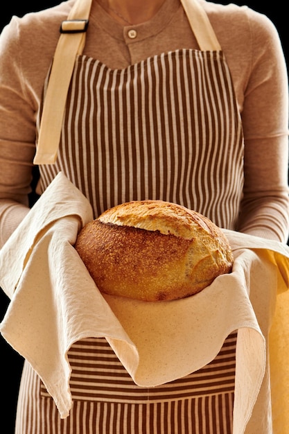 Panettiere che tiene pagnotta di pane fatto in casa