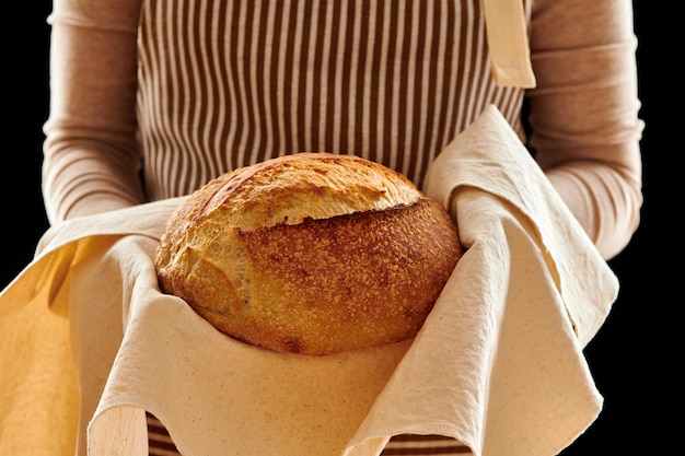 Panettiere che tiene pagnotta di pane fatto in casa