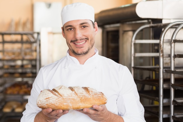 Panettiere che tiene pagnotta di recente cotta