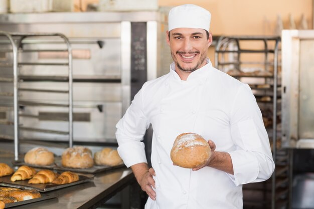 Panettiere che tiene una pagnotta di recente cotta