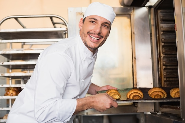 Panettiere felice che elimina i croissant freschi