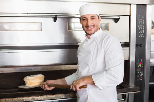 Panettiere felice che elimina pagnotta fresca