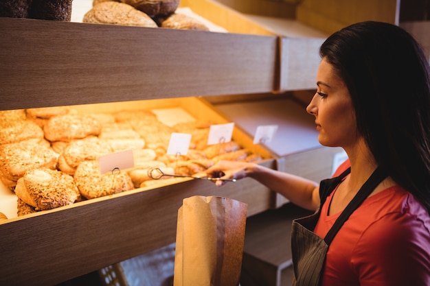 Panettiere femminile che imballa alimento dolce