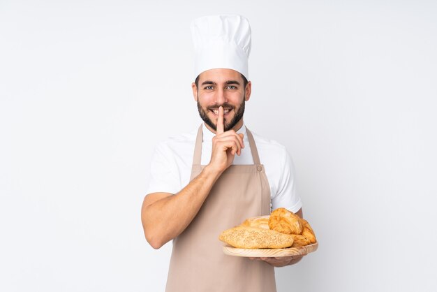 Panettiere maschio che tiene una tabella con parecchi pani isolati