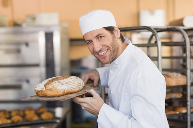 Panettiere sorridente che sente l&#39;odore del pane fresco