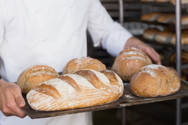 Panettiere tenendo il vassoio di pane