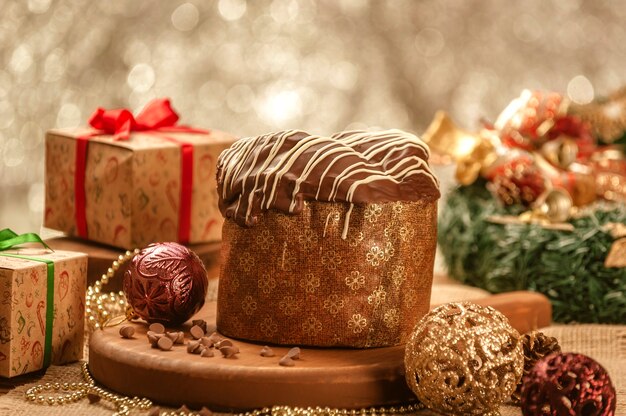 Panettone al cioccolato sulla tavola di legno con ornamenti natalizi