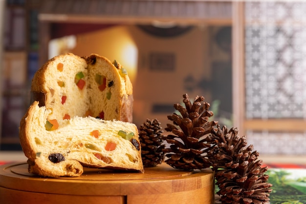 panettone classico italiano su un tavolo decorato con pigne in attesa del Natale