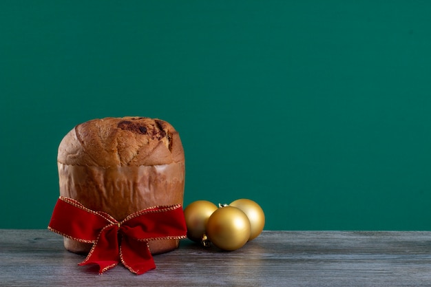 Panettone di torta al cioccolato natalizia con un nastro rosso in un panetone chroma backgroundor cho